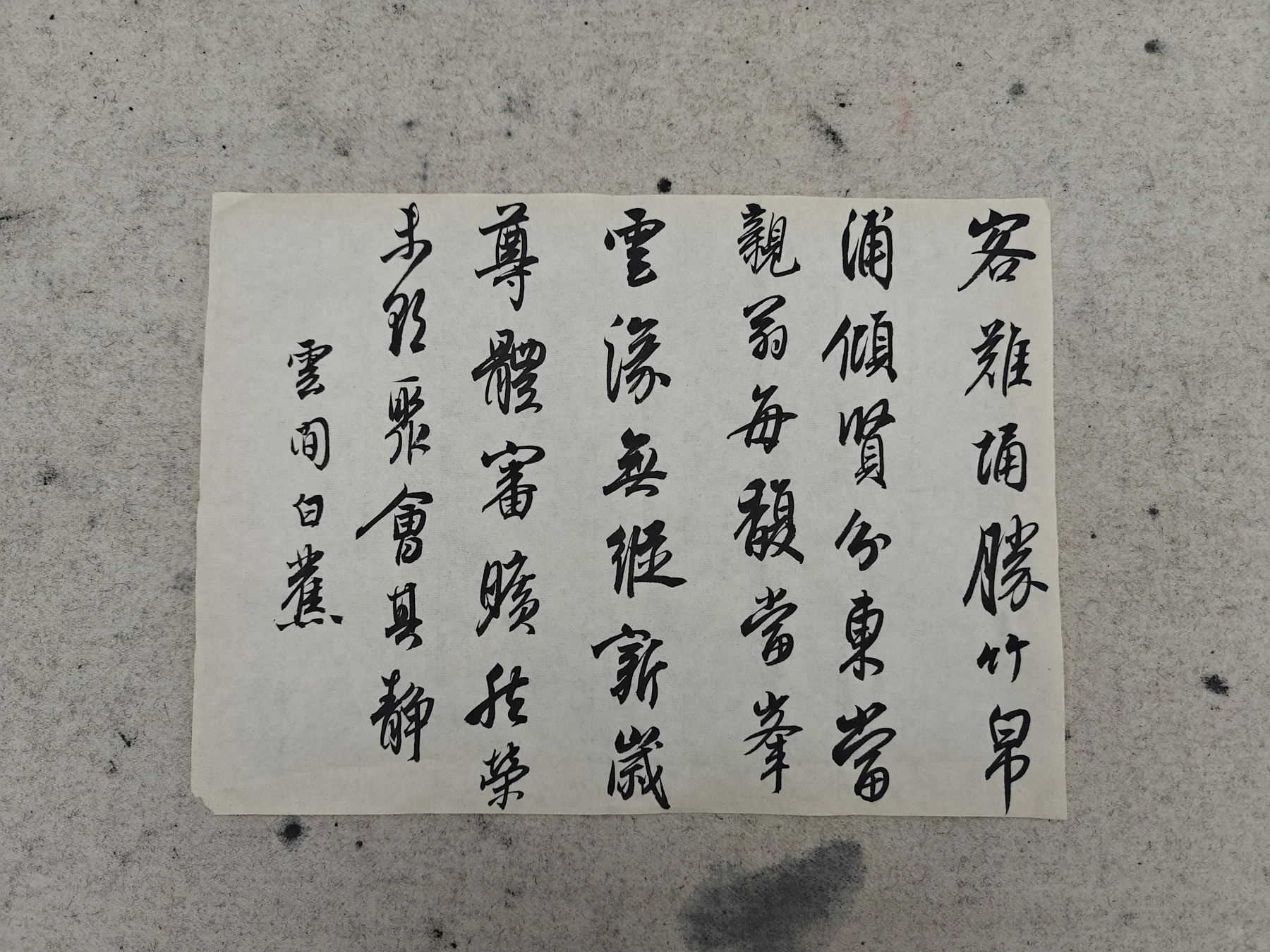 A handwritten calligraphy study in black ink on a sheet of paper